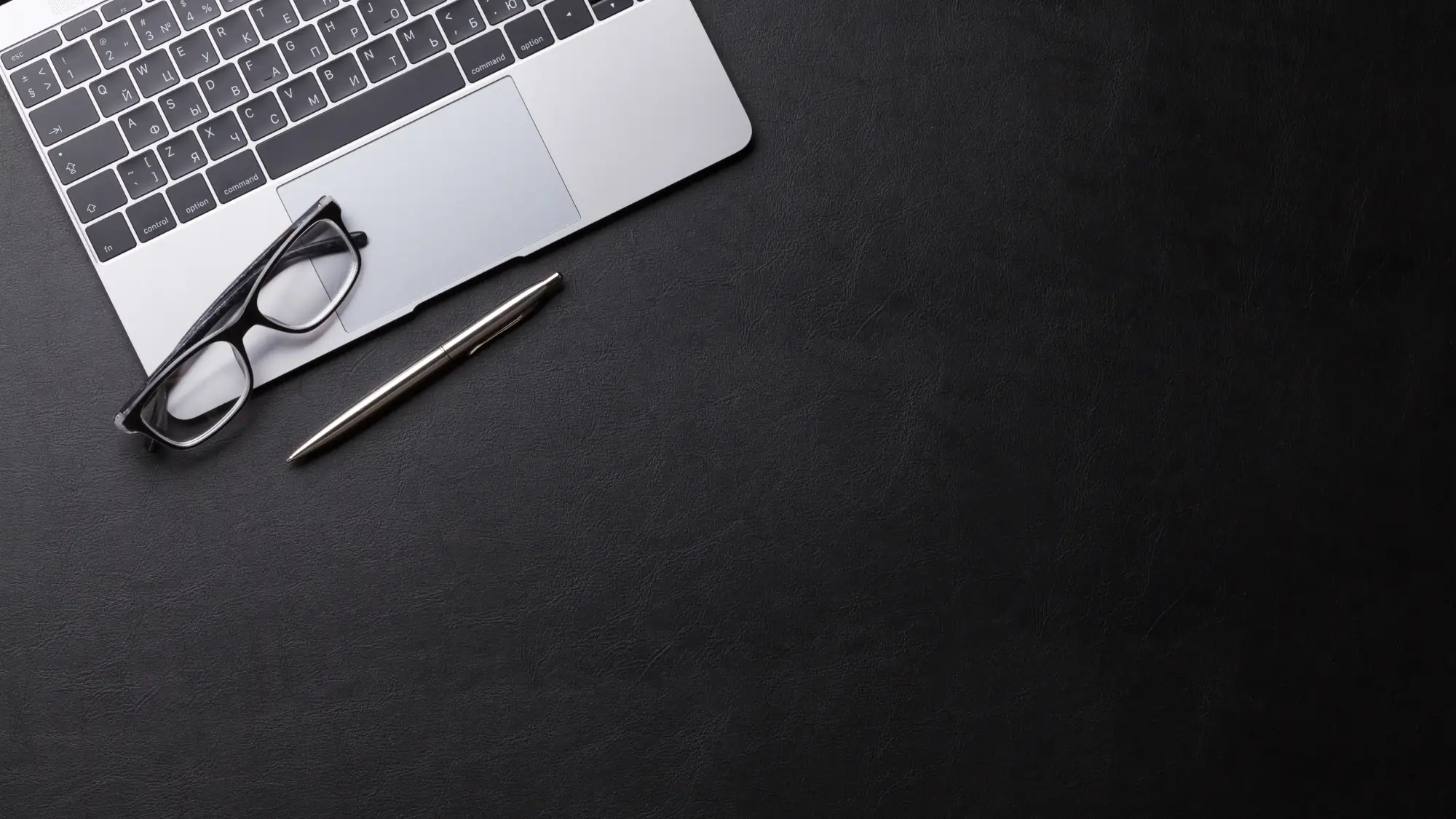 top view of a black desk with laptop